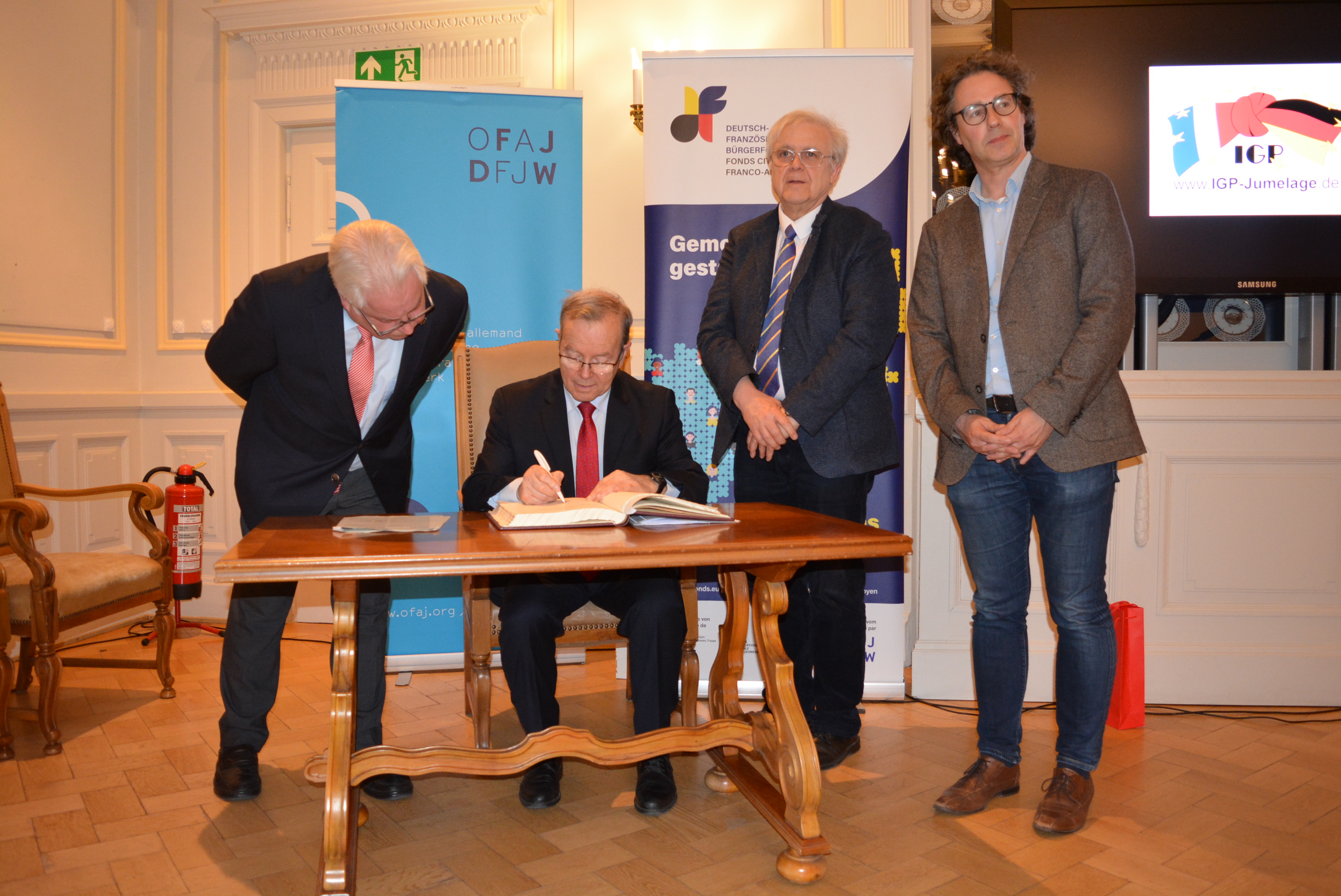 Le professeur Henri Ménudier signe le livre d'or de la commune d'Edingen-Neckarhausen en présence de l'adjoint au maire et de deux membres du comité directeur de l'association de jumelage